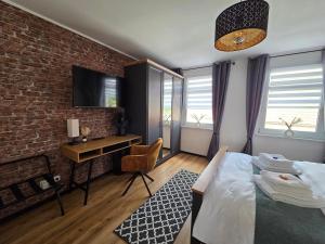 a bedroom with a bed and a desk and a brick wall at Haus Kabelitz in Kabelitz