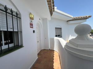 ein Flur eines weißen Gebäudes mit einer weißen Tür in der Unterkunft La Barrosa in Novo Sancti Petri