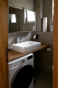 a bathroom with a sink and a washing machine at Valeri Lux Becici in Rafailovici +15 photos