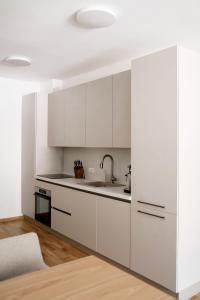 a kitchen with white cabinets and a sink at Valeri Lux Becici in Rafailovici