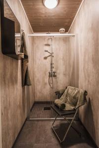 a bathroom with a shower with a chair in it at Ljøratunet Storhytte in Ljørdalen