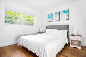 a white bedroom with a large bed and a window at The Coastal Dream! Only 3miles to the beach, Fast WiFi, Garage in Naples