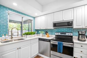 a kitchen with white cabinets and a stove top oven at The Coastal Dream! Only 3miles to the beach, Fast WiFi, Garage in Naples