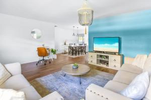 a living room with a couch and a tv at The Coastal Dream! Only 3miles to the beach, Fast WiFi, Garage in Naples