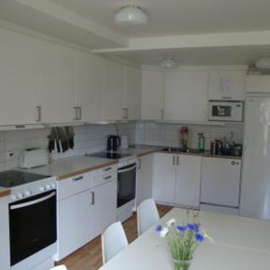 a kitchen with white cabinets and a table with flowers on it at Kalmar Sjömanshem in Kalmar