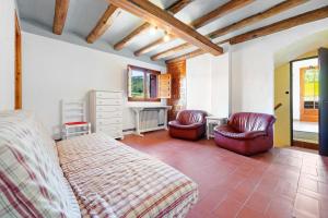 - une chambre avec deux chaises, un lit et un bureau dans l'établissement Masia Caltiku, à El Pla de Manlleu