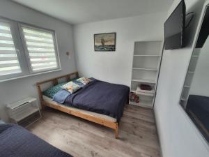 a bedroom with a bed and a book shelf at Noclegi u Loni - Szary domek - noclegi w zacisznym centrum Pobierowa nad morzem z parkingiem in Pobierowo