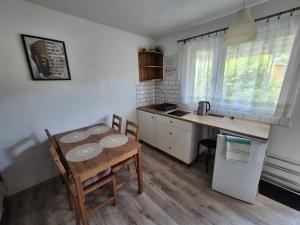 a small kitchen with a table and a table and a table and chairs at Noclegi u Loni - Szary domek - noclegi w zacisznym centrum Pobierowa nad morzem z parkingiem in Pobierowo