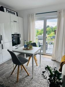 a living room with a white table and a kitchen at FeWo S26 in Krumbach
