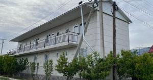 un gran edificio blanco con balcón. en Edelweiss 1, en Cholpon-Ata