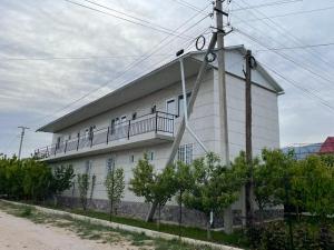 a white building with a balcony on the side of it at Edelweiss 1 in Cholpon-Ata