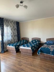 Un dormitorio con dos camas y una ventana con cortinas. en Edelweiss 1, en Cholpon-Ata 24 fotos más