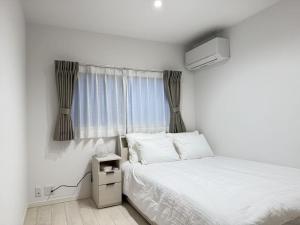 a small bedroom with a bed and a window at Akikawa Ｍashiki 2 in Mashiki