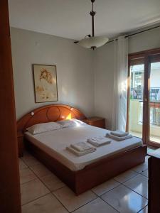 a bedroom with a large bed with towels on it at LA.KI House in Kavala