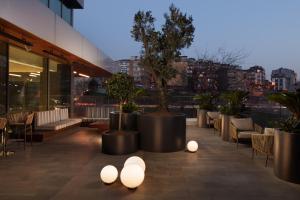 a rooftop patio with tables and chairs and lights at Four Points by Sheraton Istanbul Kagithane in Istanbul +50 photos