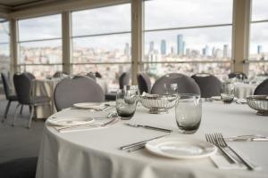 a table with white plates and glasses on it at Four Points by Sheraton Istanbul Kagithane in Istanbul