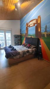 a bedroom with a large bed with a sign on the wall at Nuestro sueño jurásico in Barreiros
