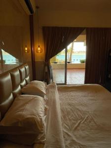 a bed in a room with a large window at شاليه البرادايس 26 في درة العروس in Durat  Alarous