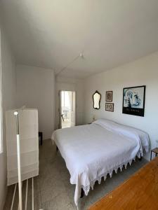 a white bedroom with a large bed and a window at Panorama nel borgo in Monteciccardo