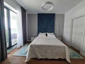 a bedroom with a large bed and a large window at Residence Sole by Axxis Nova Resort - Apartament luxury 70mp cu terasa si vedere la mare, acces direct pe plaja Axxis Beach BluFlag - Mamaia Nord - Parcare gratuita in Mamaia