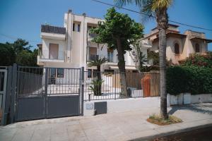 a fence in front of a house with a building at Regina Elena Luxury Apartments in Mondello +15 photos
