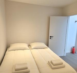 雷克雅未克Comfortable and charming home的一间卧室配有带两个枕头的床和一扇门