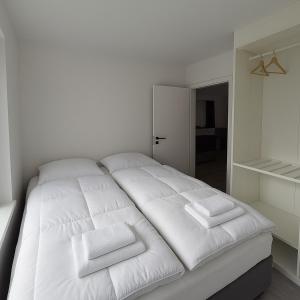 雷克雅未克Comfortable and charming home的一张白色的床,上面有三个枕头