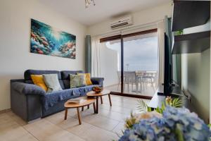 a living room with a blue couch and a tv at Glabur Stays! The One -1 - Elite Marina Front! in Zygi