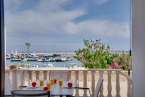 a table and chairs on a balcony with a marina at Glabur Stays! The One -1 - Elite Marina Front! in Zygi