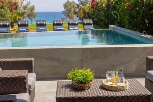 una mesa con botellas y vasos junto a una piscina en Villa Adalia, en Protaras 73 fotos más