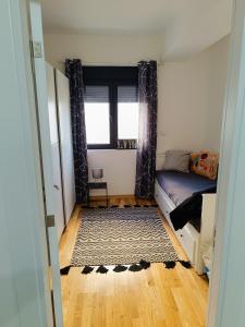 a small bedroom with a bed and a rug at Cozy 2BR apt in Podgorica