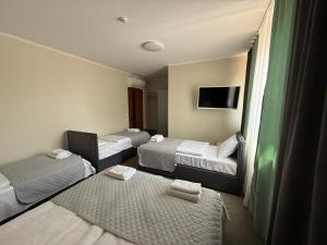 a hotel room with three beds and a tv at Ресторан-Готель Шеркерт in Berehove +67 photos