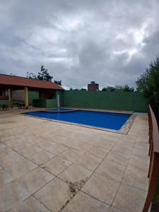 an empty swimming pool in a yard with a green fence at Aconchegante Casa em Gravatá - Casa 10 in Gravatá