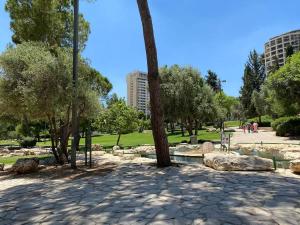 ein Park mit Bäumen und Felsen und einem Teich in der Unterkunft Suite deluxe 3 pieces Haim Weizmann in Jerusalem