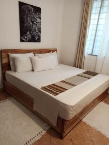 a bedroom with a large bed with a wooden frame at SK Homes in Kilifi
