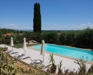a swimming pool with chairs and umbrellas at Casal di Peppe B&B in Lorenzana