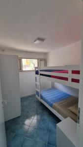 ein Schlafzimmer mit zwei Etagenbetten in einem Zimmer in der Unterkunft Villa Dei Santi, Azzurro in Santa Maria di Castellabate