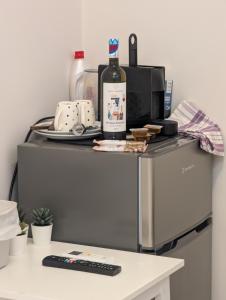 a table with a bottle of wine on top of a refrigerator at Eva Beach Studio in Néa Péramos