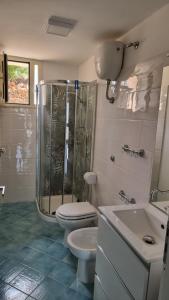 ein Badezimmer mit Dusche, Toilette und Waschbecken in der Unterkunft Villa Dei Santi, Azzurro in Santa Maria di Castellabate + 8 Fotos
