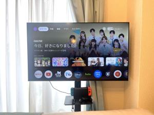 a flat screen tv hanging on a wall at Naos House Hotel Osaka 5 in Osaka