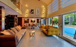 Una sala de estar con sofás y un comedor. en Maison, en Maxilly-sur-Léman