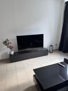 a living room with a flat screen tv on a wall at Modernes Apartment in Essen Nähe Messe in Essen +6 photos