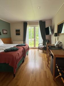 トローサにあるTrosa Åda Krog Hotell & Konferensのベッドと机と窓があるホテルの部屋