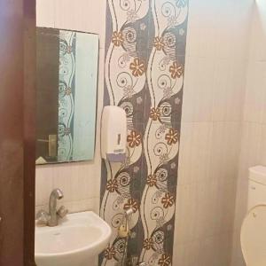 baño con lavabo y teléfono en la pared en Hotel Gem, en Jaipur