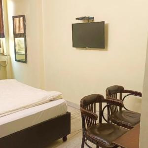 Un dormitorio con una cama y dos sillas y una mesa. en Hotel Gem, en Jaipur