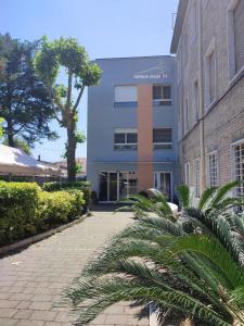 a building with palm trees in front of it at Campus Circuito 71 - Casa per Ferie in Pescara