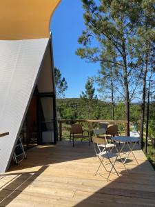a patio with a table and chairs on a deck at Uxa Paraiso in Penela
