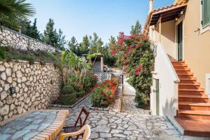a stone pathway with benches and flowers next to a building at Villa sea view 1 in Athanion