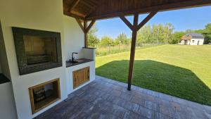 a patio with a fireplace and a view of a field at Osada Mech i Fale in Tarnobrzeg