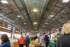 a group of people walking around a farmers market at Cours Massena in Antibes